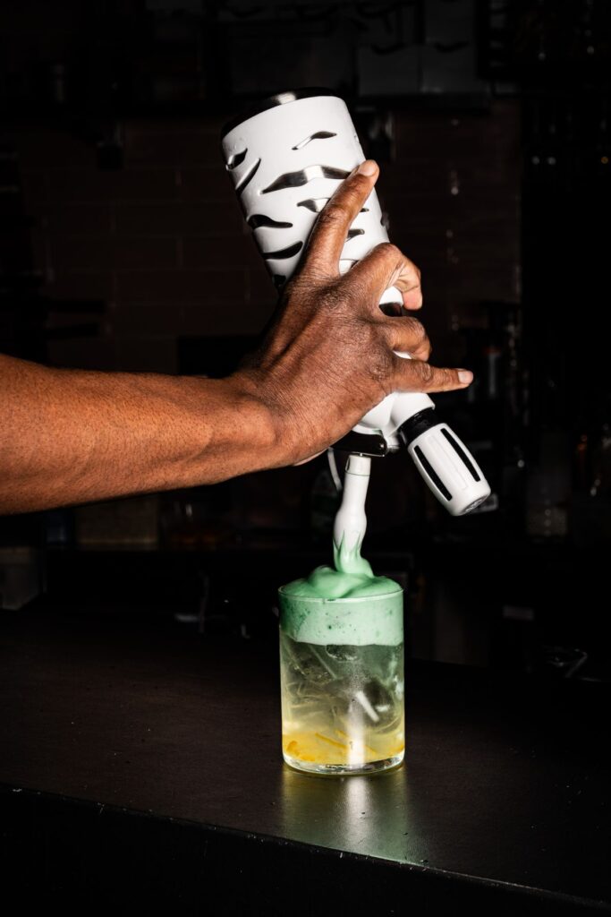 Bartender maakt groen schuim op een cocktail bij Diego's