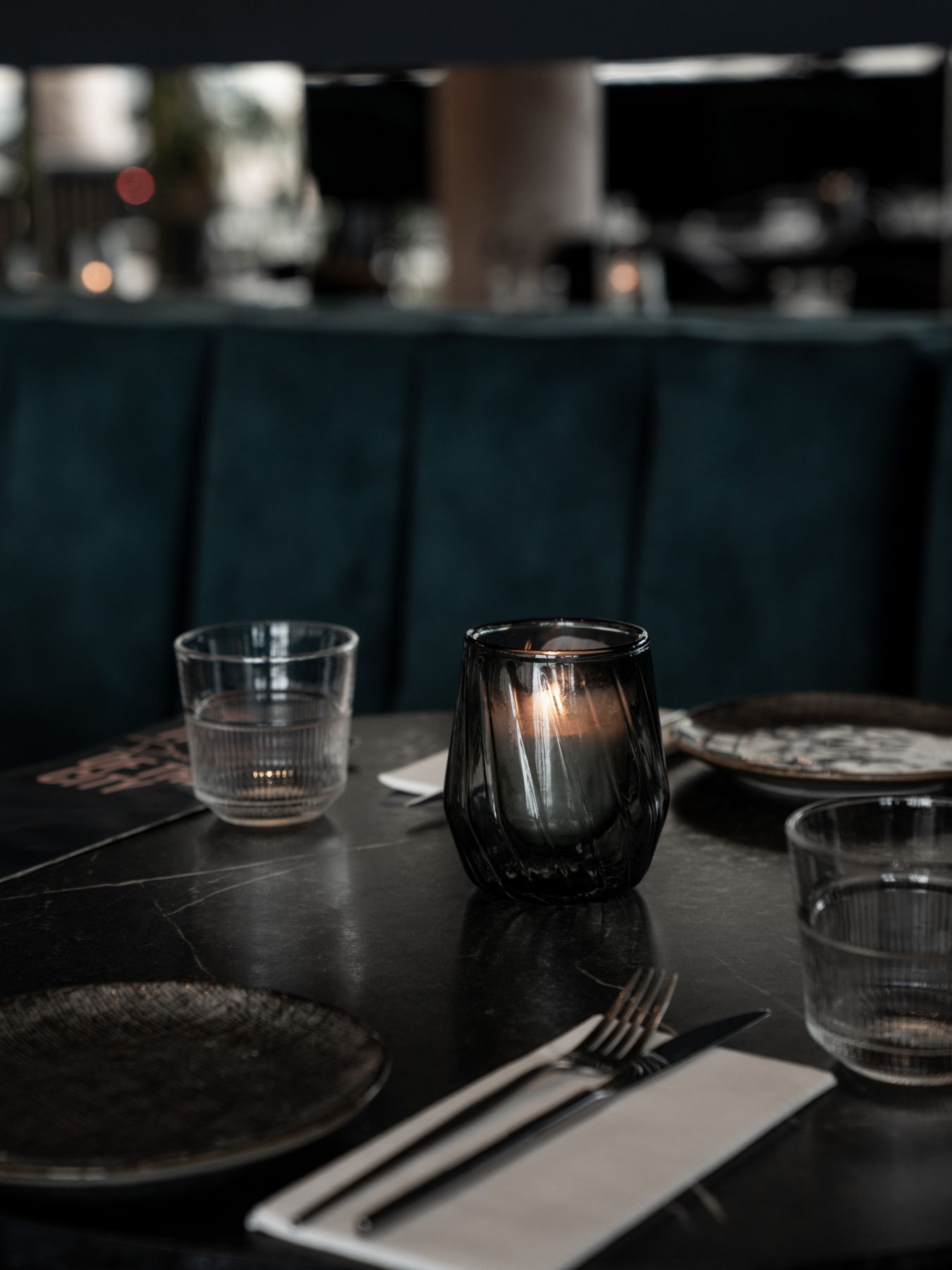 Gedekte tafel met kaarsje en fluwelen bank bij Diego's Rotterdam